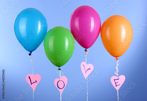 Colorful balloons keeps word  love  on blue background