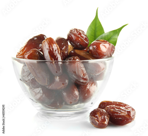 Dried dates in glass bowl isolated on white photo