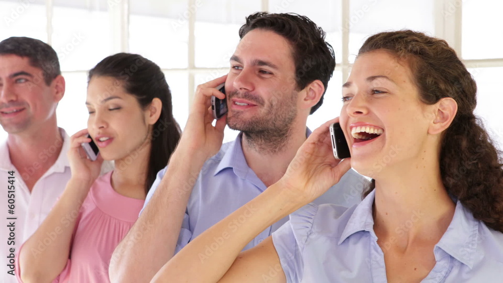 Cheerful designer standing in a row while phoning Cheerful designer standing in a row while phoning