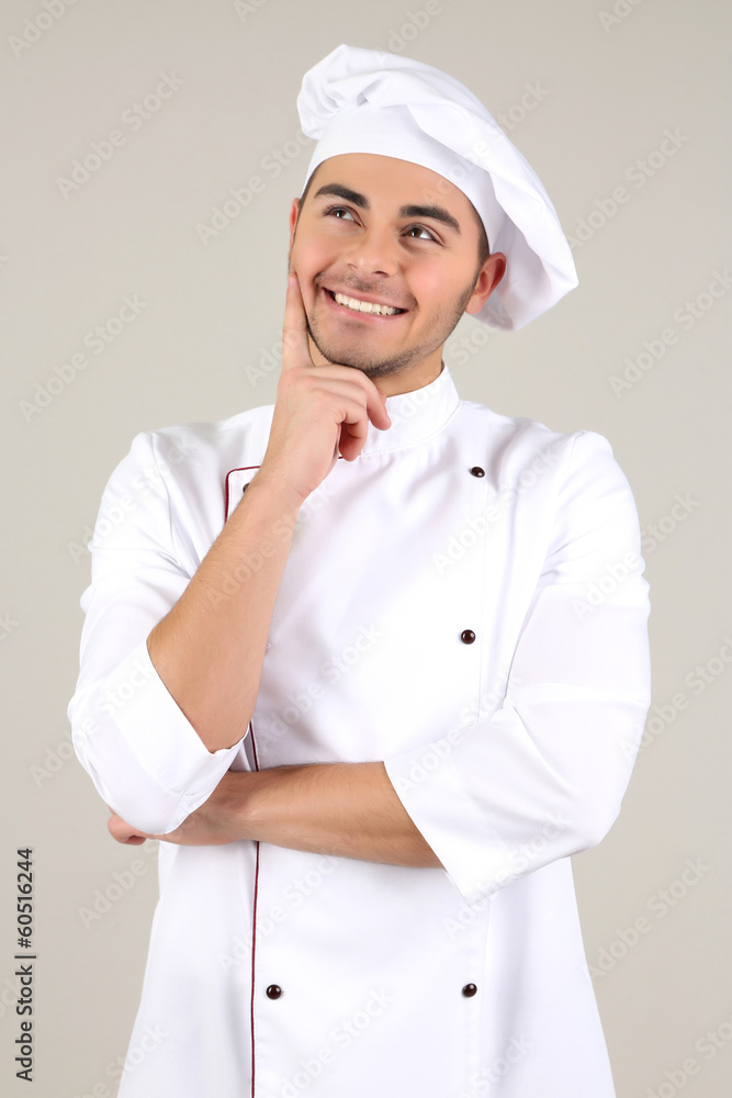 Professional chef in white uniform and hat, on gray background Professional chef in white uniform and hat, on gray background