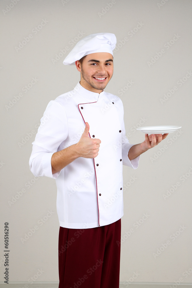 Professional chef in white uniform and hat, on gray background Professional chef in white uniform and hat, on gray background