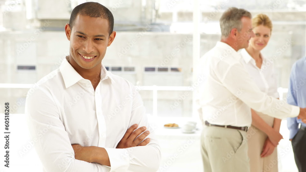 Businessman smiling in front of his staff Businessman smiling in front of his staff