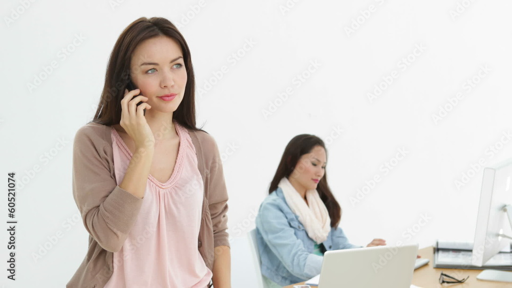 Creative businesswoman talking on phone with colleague Creative businesswoman talking on phone with colleague