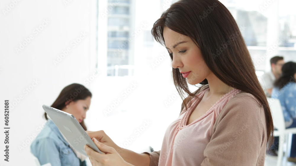 Creative businesswoman using tablet pc with colleagues Creative businesswoman using tablet pc with colleagues