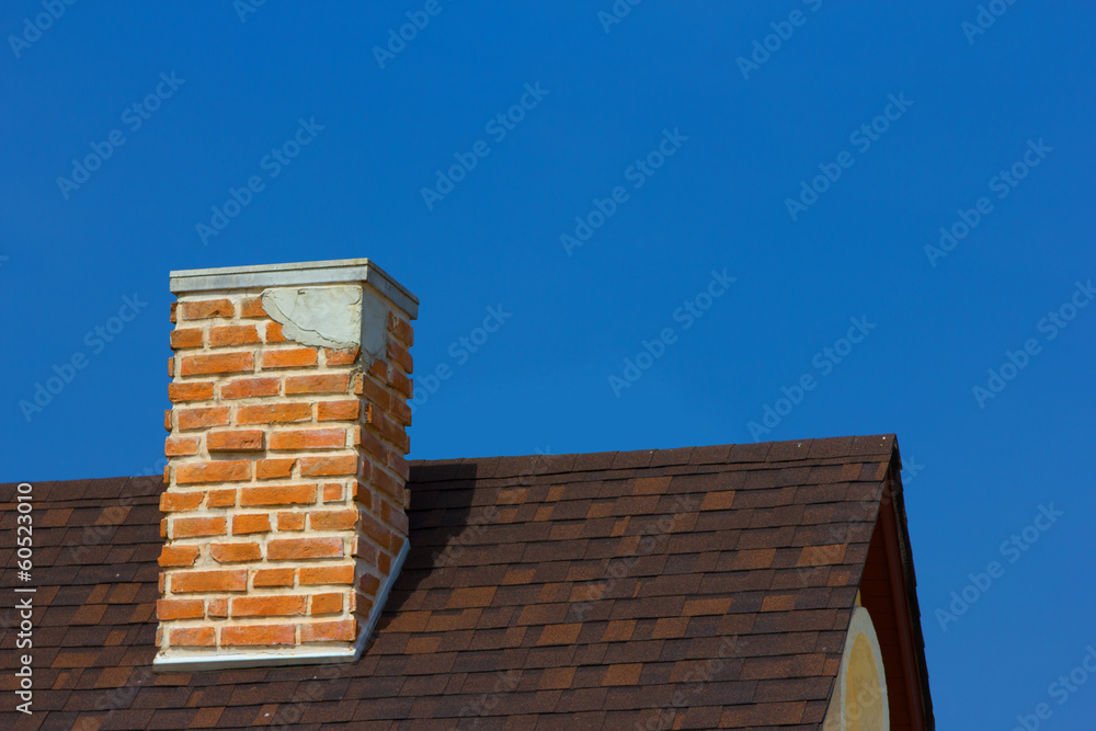 The brick chimney in bright sunlight a deep blue sky horizontal