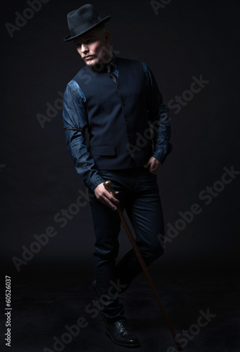 Retro 1900 modern fashion man. Holding walking cane. Wearing blu © ysbrandcosijn
