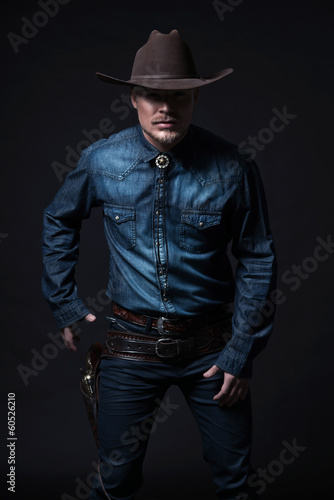 Modern fashion cowboy. Wearing brown hat and blue jeans shirt. P © ysbrandcosijn