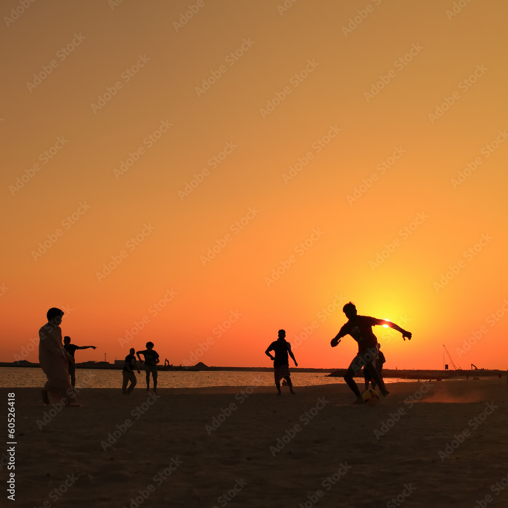 Football at Jumeira beach in Dubai during sunset. Football at Jumeira beach in Dubai during sunset.