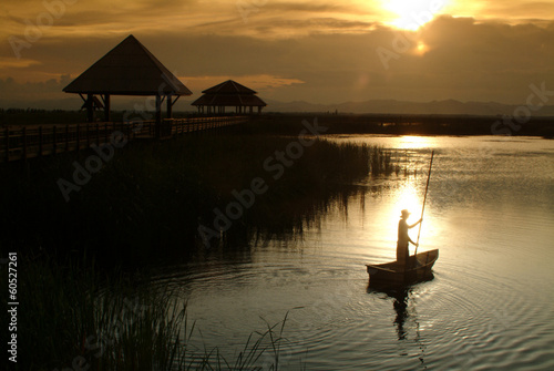 Obraz na plátně Thai villager punt on lake in Sunset .