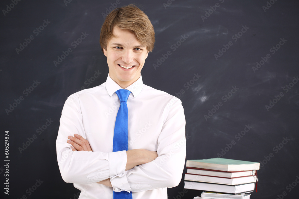 Radosny student na tle czarnej tablicy Radosny student na tle czarnej tablicy