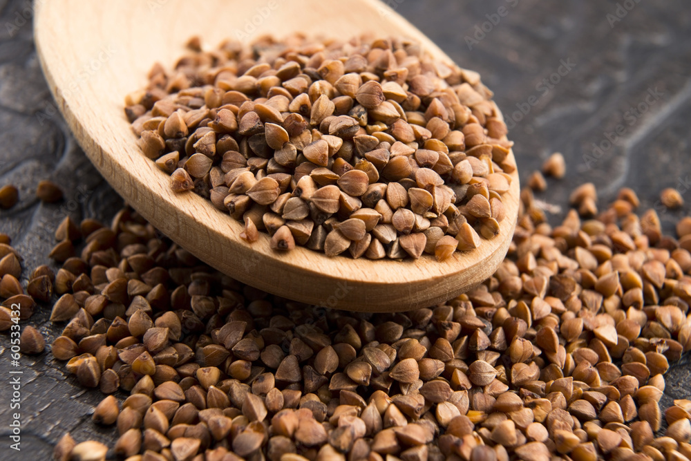Buckwheat seeds on wooden spoon in closeup Buckwheat seeds on wooden spoon in closeup