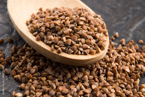 Buckwheat seeds on wooden spoon in closeup