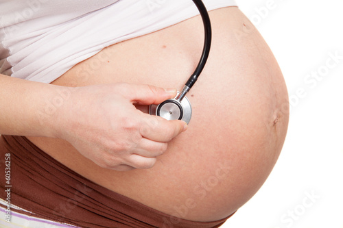pregnant woman listening her belly with stethoscope