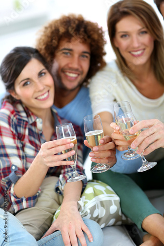 Closeup of friends cheering with glass of wine
