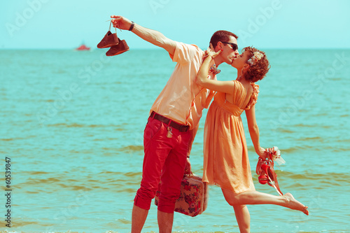 Couple walking on beach. Married hipsters in trendy clothes