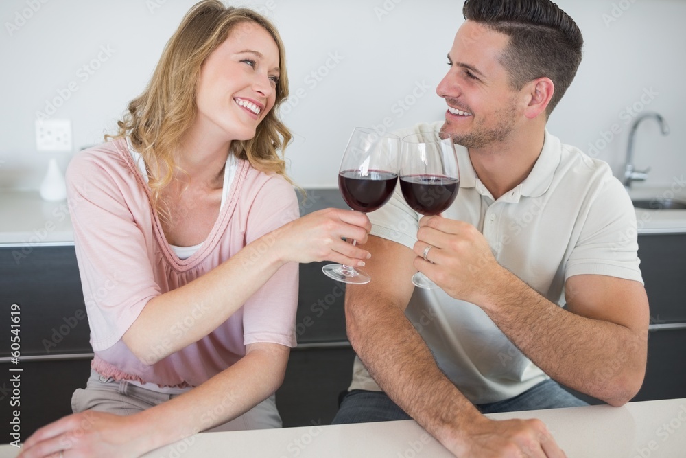 Couple toasting red wine glasses at table Couple toasting red wine glasses at table