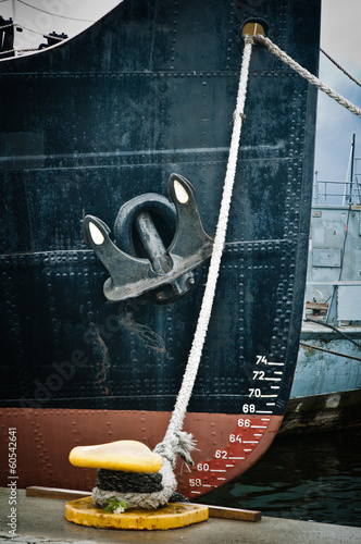 Nose of the moored ship with an anchor on a board