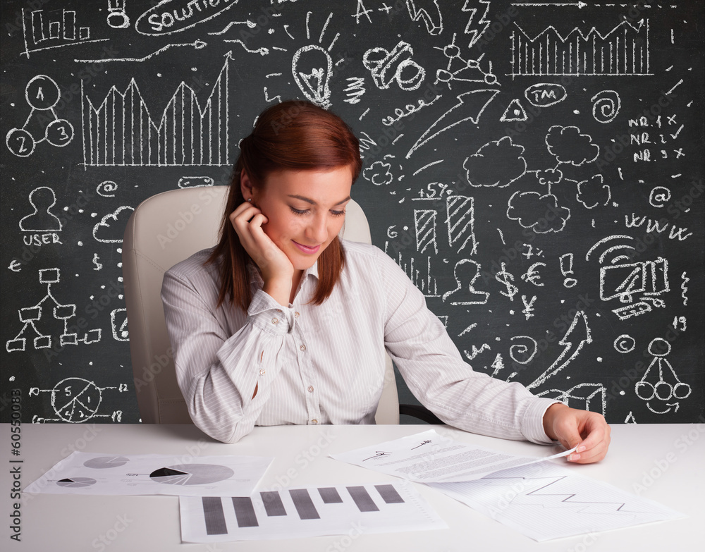 Fototapeta premium Businesswoman sitting at desk with business scheme and icons