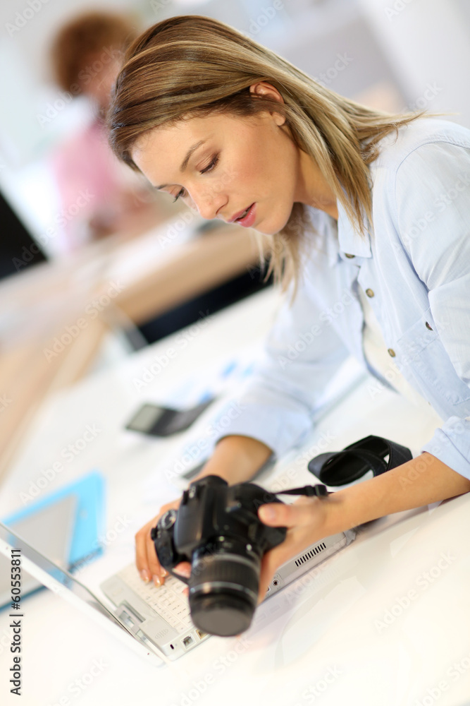 Woman reporter in office looking at photo camera Woman reporter in office looking at photo camera