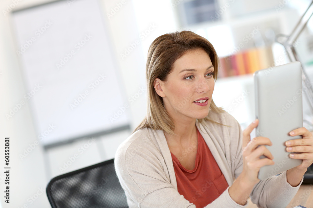 Businesswoman in office working on digital tablet Businesswoman in office working on digital tablet