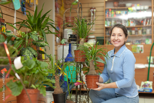 Happy mature woman with Nolina plant photo