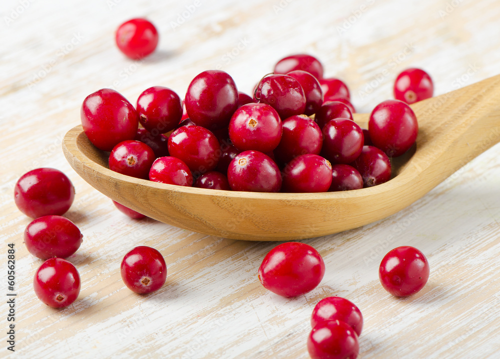 Cranberries in a wooden spoon Cranberries in a wooden spoon