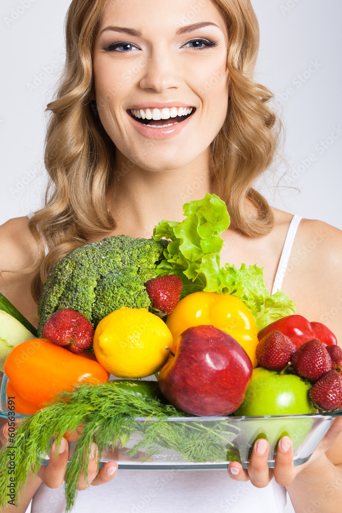 Young woman with vegetarian food, over gray Young woman with vegetarian food, over gray