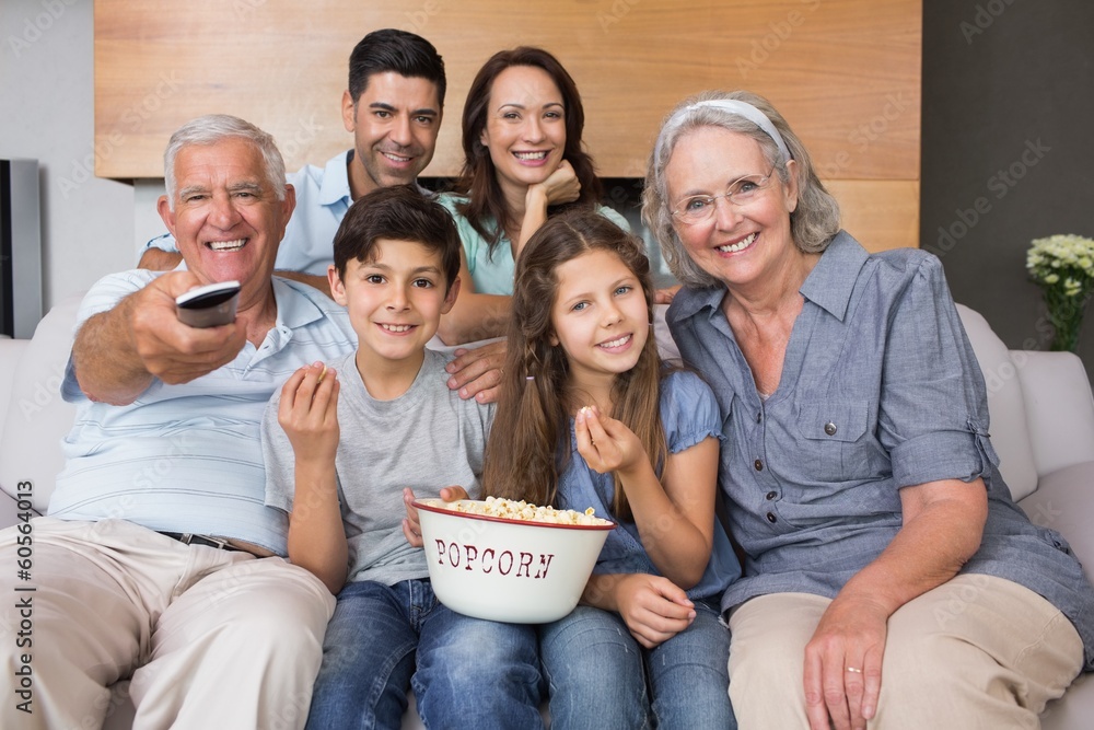 Obraz premium Portrait of happy extended family watching tv in living room