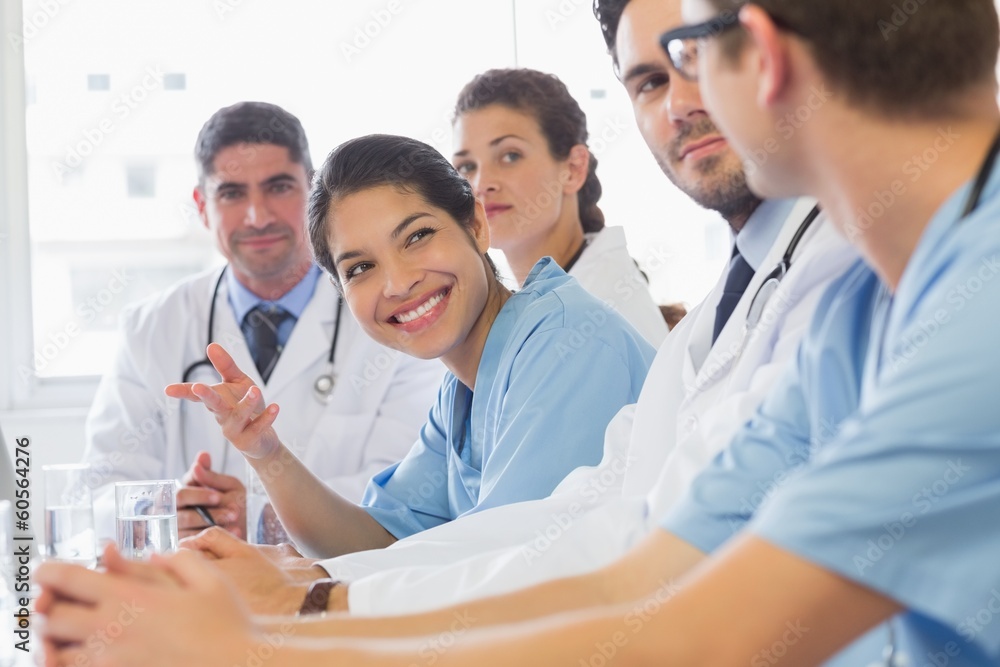 Smiling nurse looking at colleagues