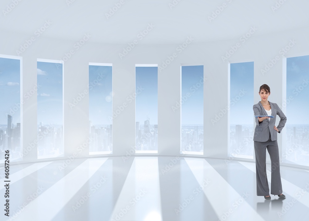 Composite image of attractive businesswoman holding tablet pc Composite image of attractive businesswoman holding tablet pc