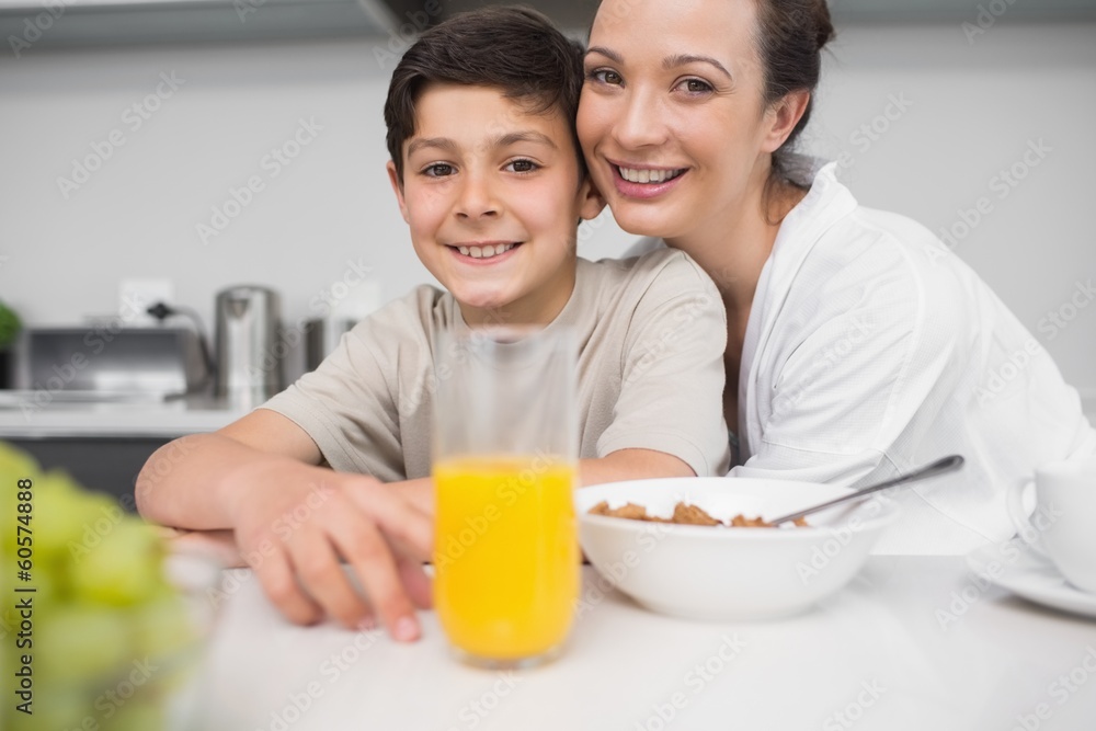 Smiling mother with son at breakfast table in kitchen Smiling mother with son at breakfast table in kitchen
