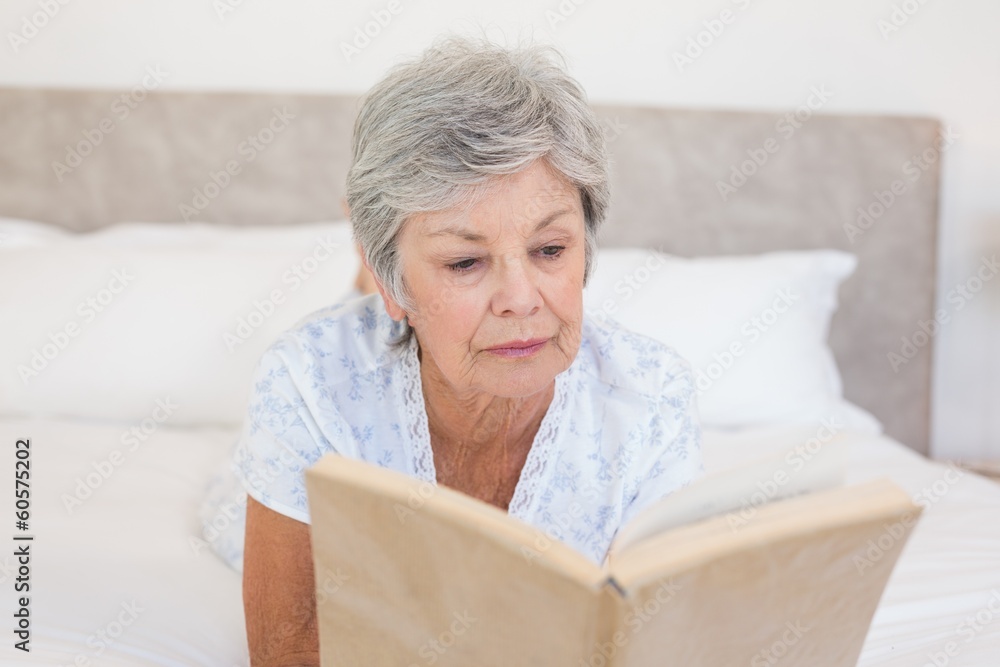 Senior woman reading story book in bed Senior woman reading story book in bed