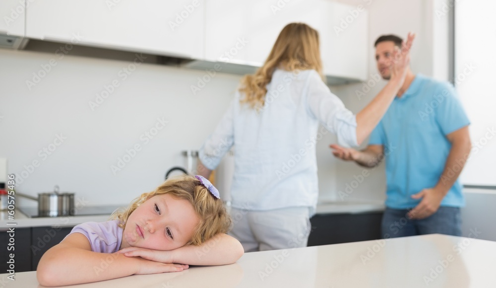 Obraz premium Bored girl leaning on table while parents arguing