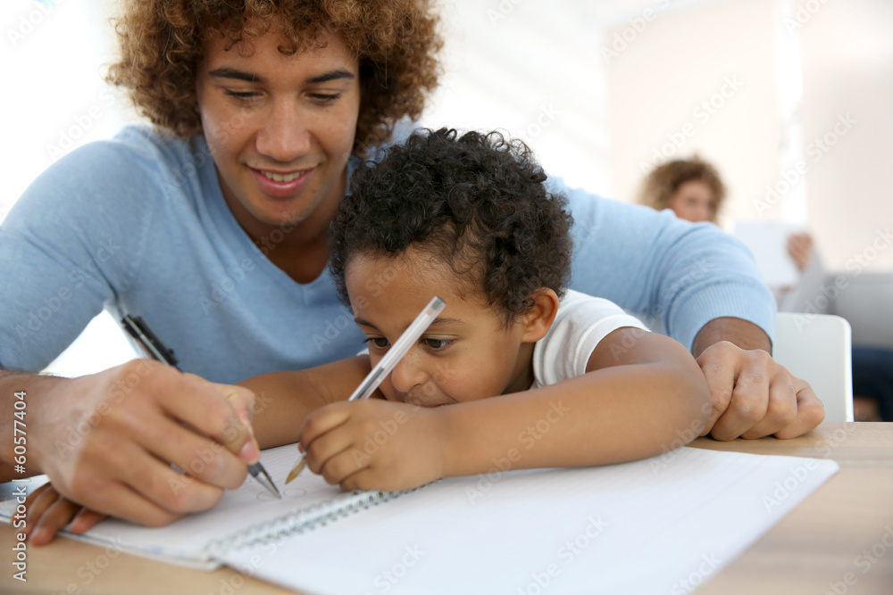 Daddy and son drawing on notebook at home Daddy and son drawing on notebook at home