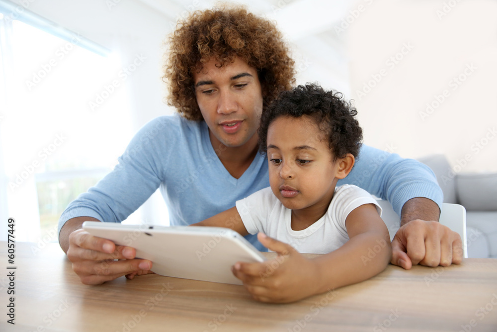 Obraz premium Father and son playing with digital tablet