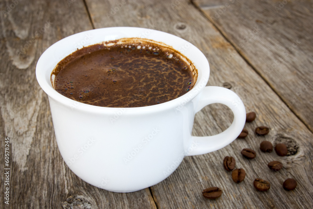 Black coffee and beans on the wooden floor Black coffee and beans on the wooden floor