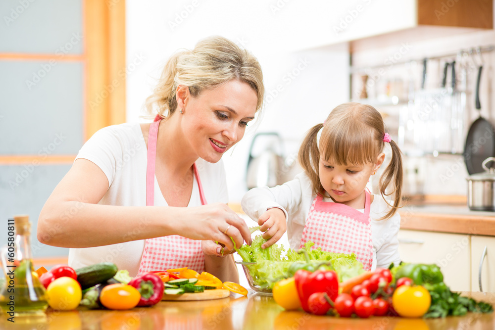 mother teaching kid daughter mixing salad at kitchen mother teaching kid daughter mixing salad at kitchen