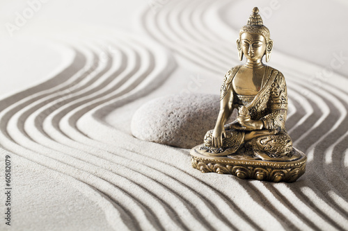 Photography Buddha in zen garden with smooth lines in sand