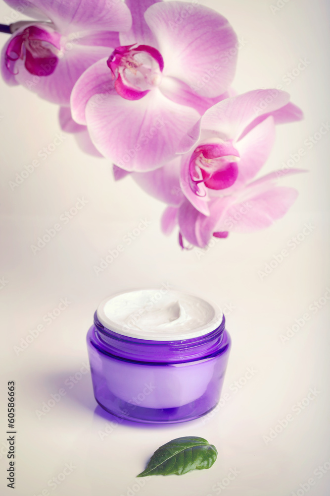 Face/hand cream jar and purple orchid flowers, vertical shot Face/hand cream jar and purple orchid flowers, vertical shot