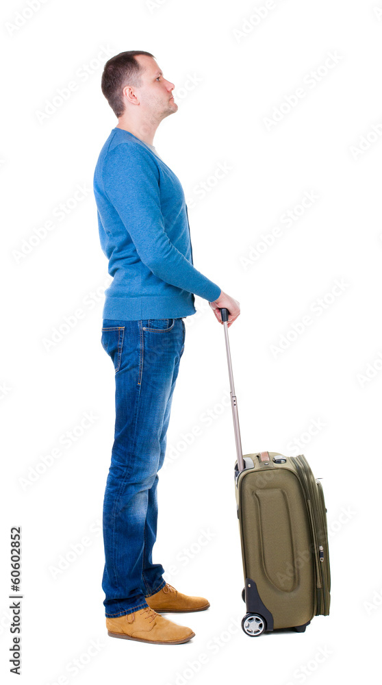 Back view of man with  green suitcase looking up.