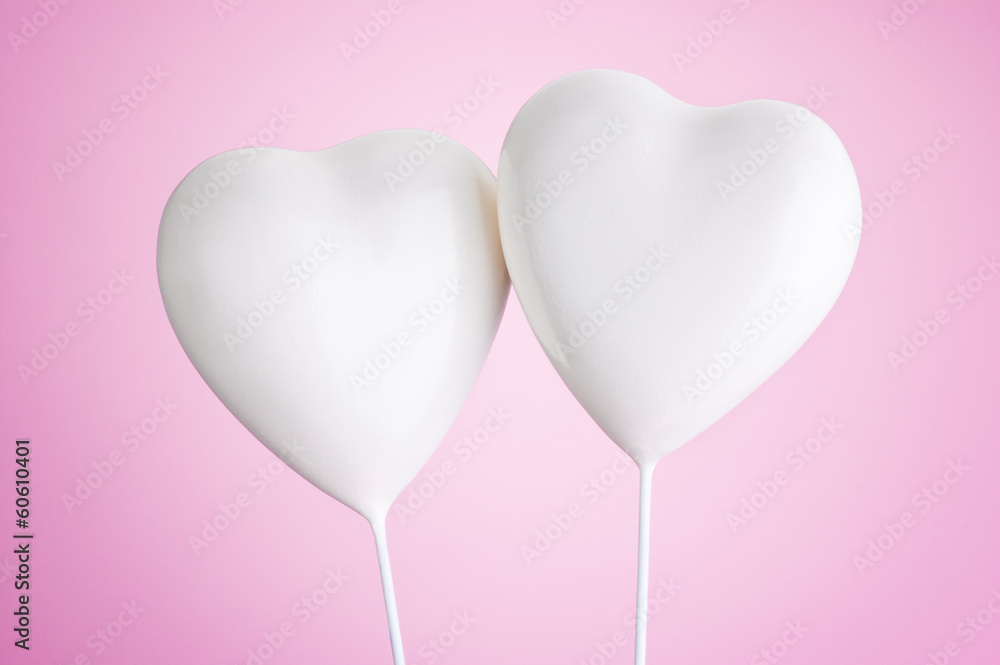 Two white hearts on a pink background