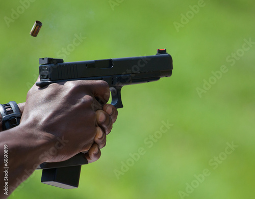 Shots Away from a semi-auto pistol with brass just flying out of the gun photo