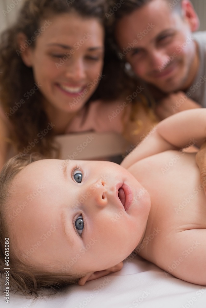 Cute baby with parents in background Cute baby with parents in background