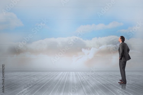 Composite image of smiling businessman with hands on hips © WavebreakMediaMicro