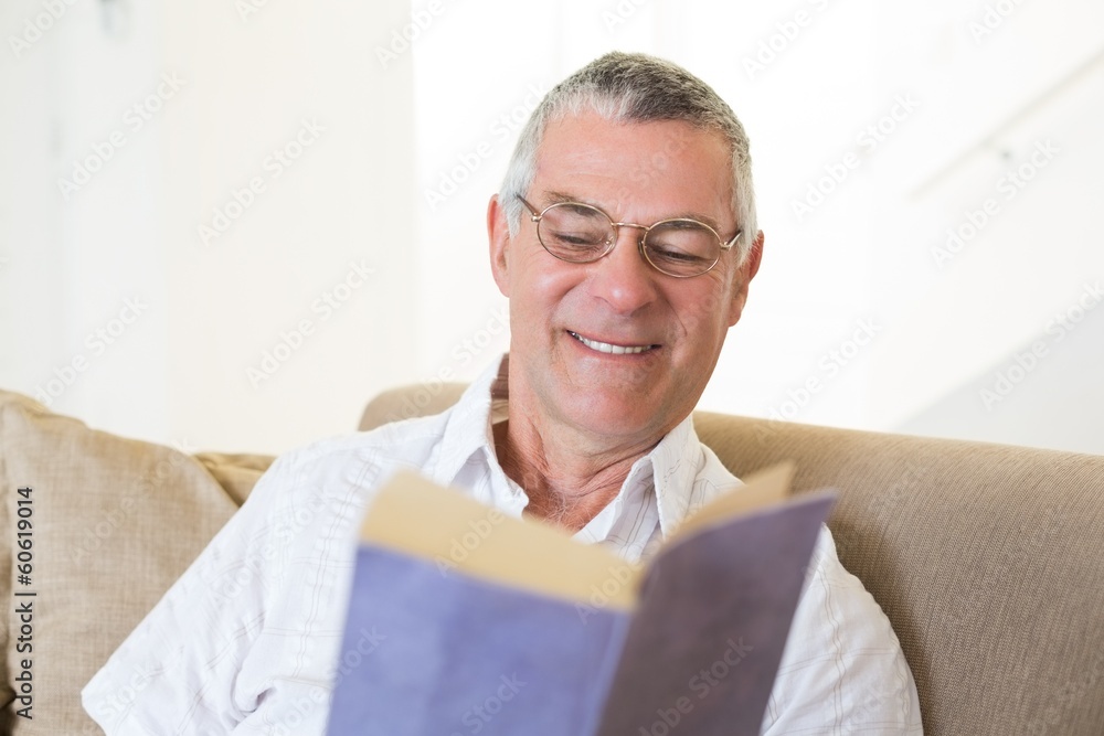 Senior man reading book on sofa Senior man reading book on sofa