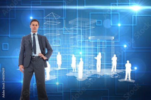 Composite image of serious businessman with hand on hip