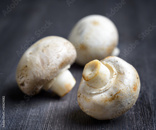 Fresh champignons on black wooden board