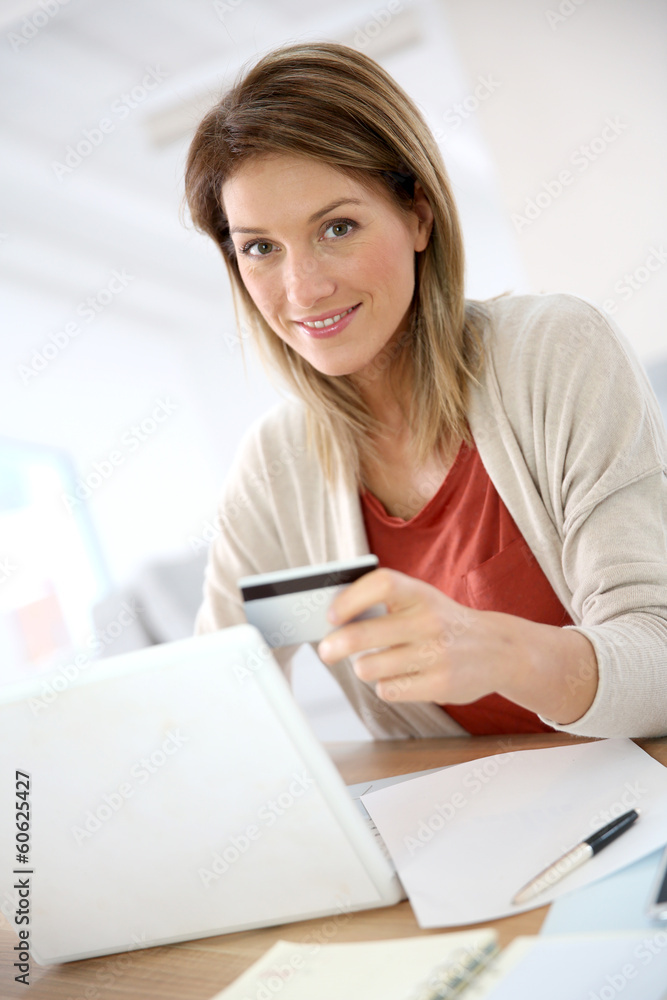 Cheerful middle-aged woman buying on internet Cheerful middle-aged woman buying on internet