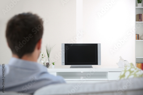 Back view of man in couch watching TV