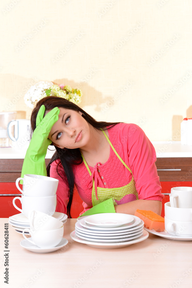 Beautiful young woman wipes clean utensils in kitchen Beautiful young woman wipes clean utensils in kitchen